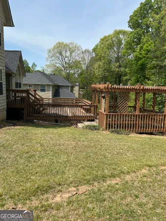 a view of house with wooden deck and furniture