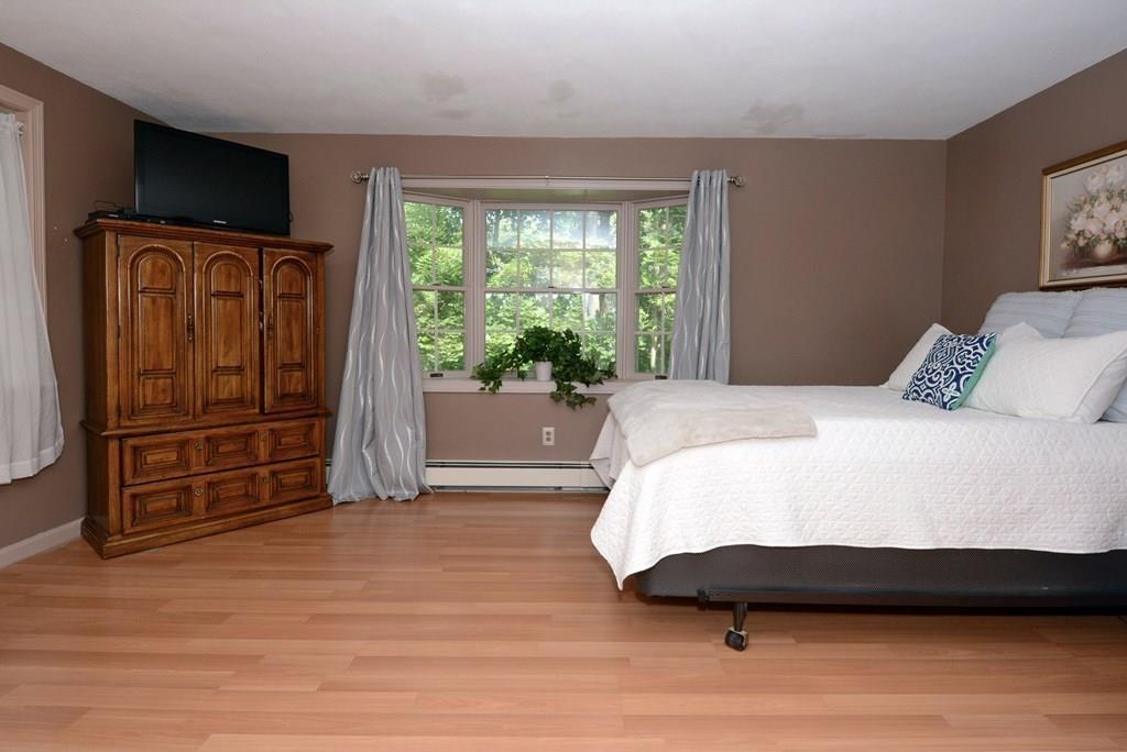 24 1st Street Amesbury, MA 01913 - Photo 12 of 42 a spacious bedroom with a bed and a television