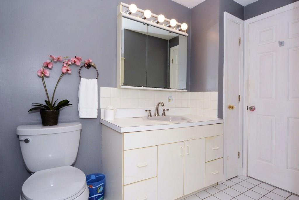 24 1st Street Amesbury, MA 01913 - Photo 16 of 42 a bathroom with a toilet sink and mirror