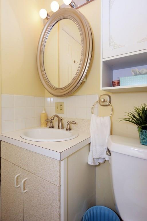 24 1st Street Amesbury, MA 01913 - Photo 28 of 42 a bathroom with a sink a toilet and a mirror