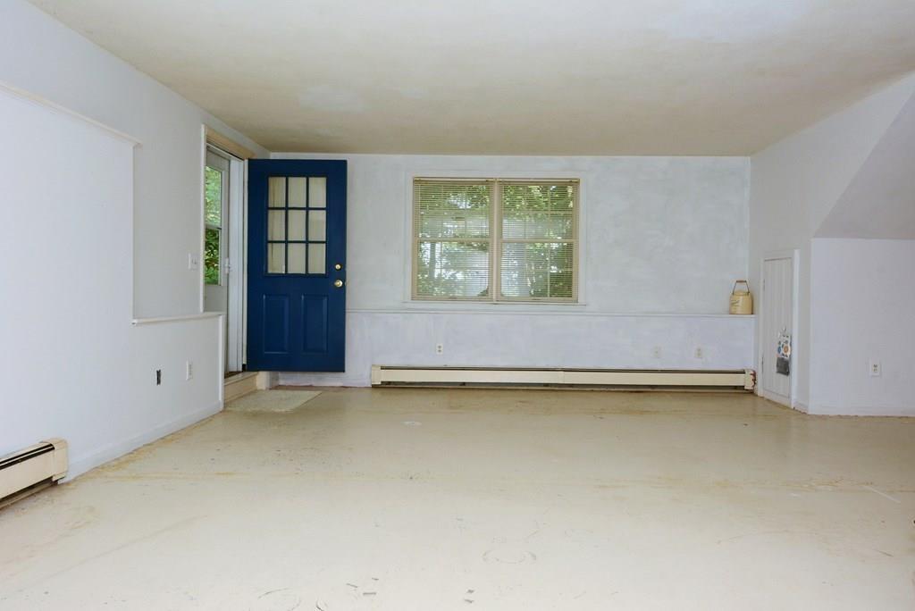 24 1st Street Amesbury, MA 01913 - Photo 29 of 42 an empty room with a fireplace and large window