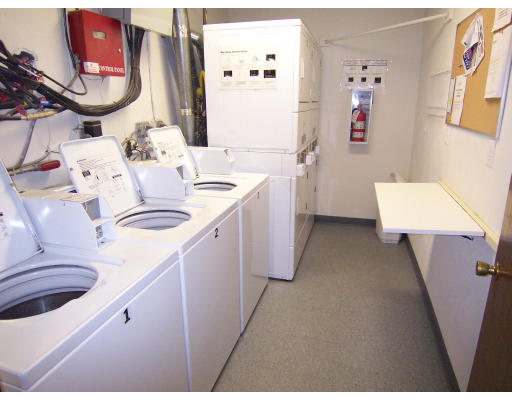 35 Glencoe Street, Unit 43 Boston, MA 02135 - Photo 15 of 19 a kitchen with a sink dishwasher a stove a dining table and chairs with wooden floor