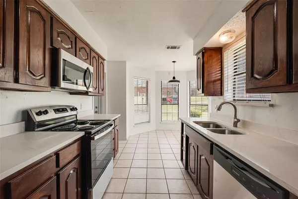 a kitchen with granite countertop a stove and a microwave