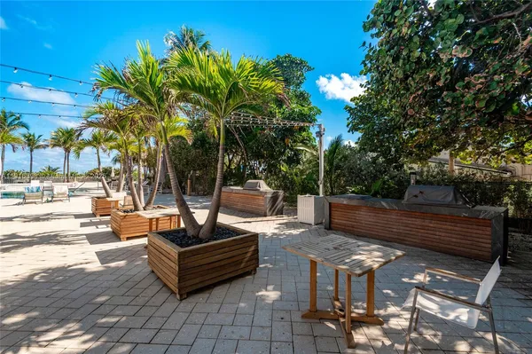 a view of a patio with table and chairs potted plants and palm tree