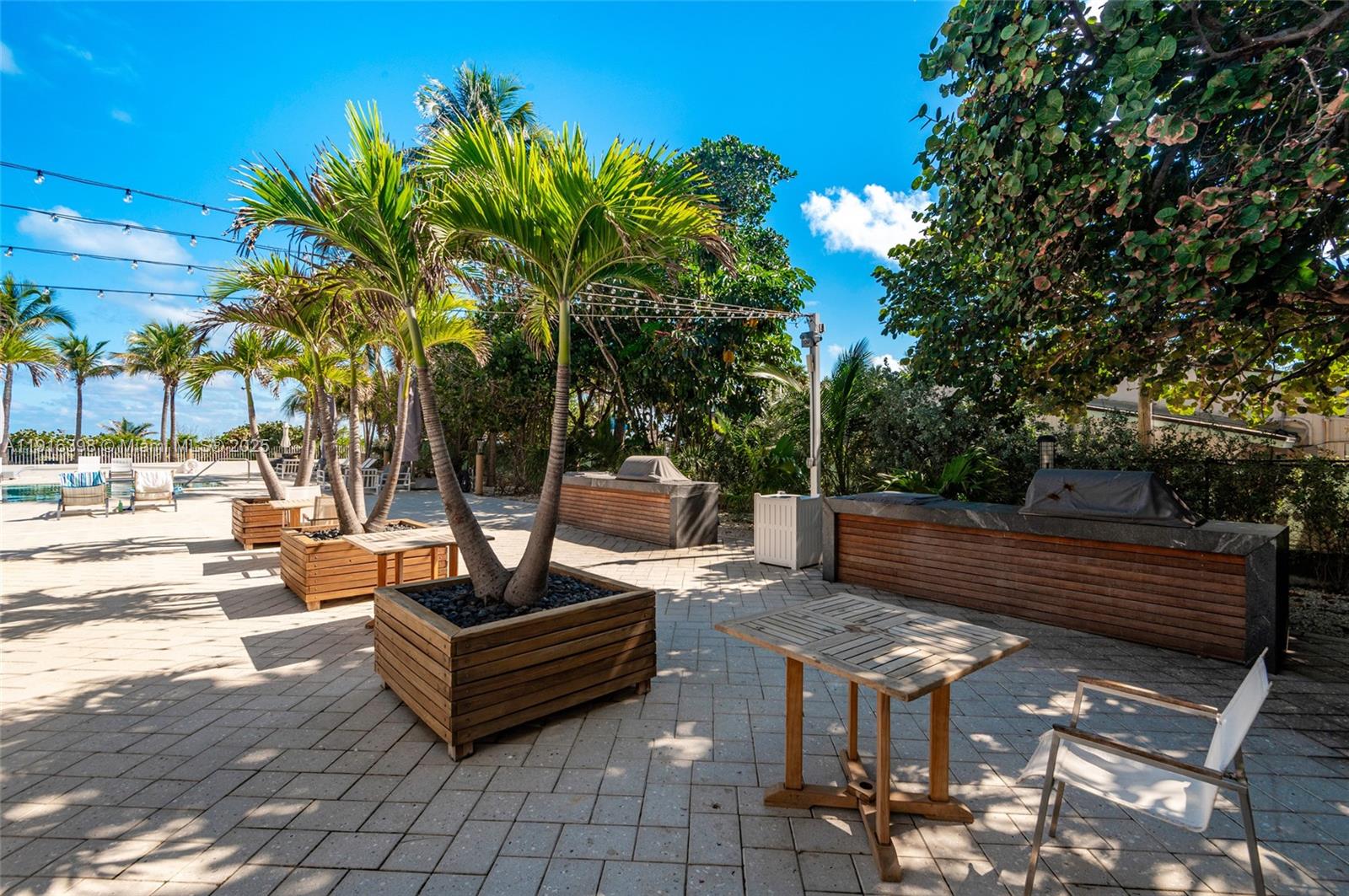 609 Ocean Drive, Unit 10H Key Biscayne, FL 33149 - Photo 3 of 21 a view of a patio with table and chairs potted plants and palm tree