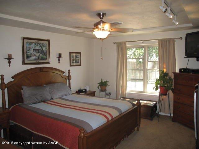 5100 Azalea Avenue Amarillo, TX 79110 - Photo 15 of 28 a bedroom with a bed and a flat screen tv