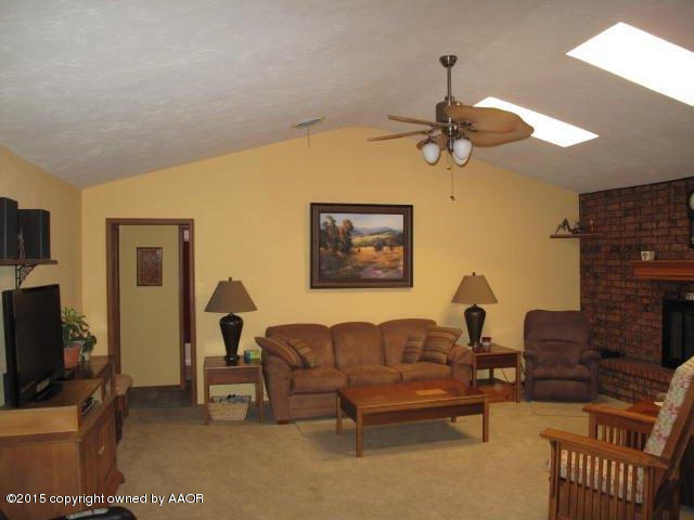 5100 Azalea Avenue Amarillo, TX 79110 - Photo 5 of 28 a living room with furniture a flat screen tv and a fireplace