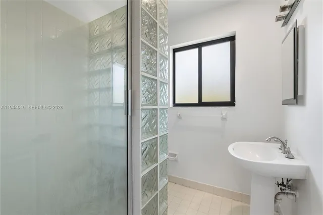 a bathroom with a sink a mirror and a shower