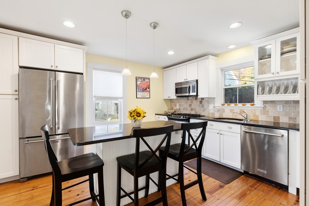 100 Willow Street Hamilton, MA 01982 - Photo 12 of 35 a kitchen with stainless steel appliances granite countertop a dining table chairs refrigerator and sink