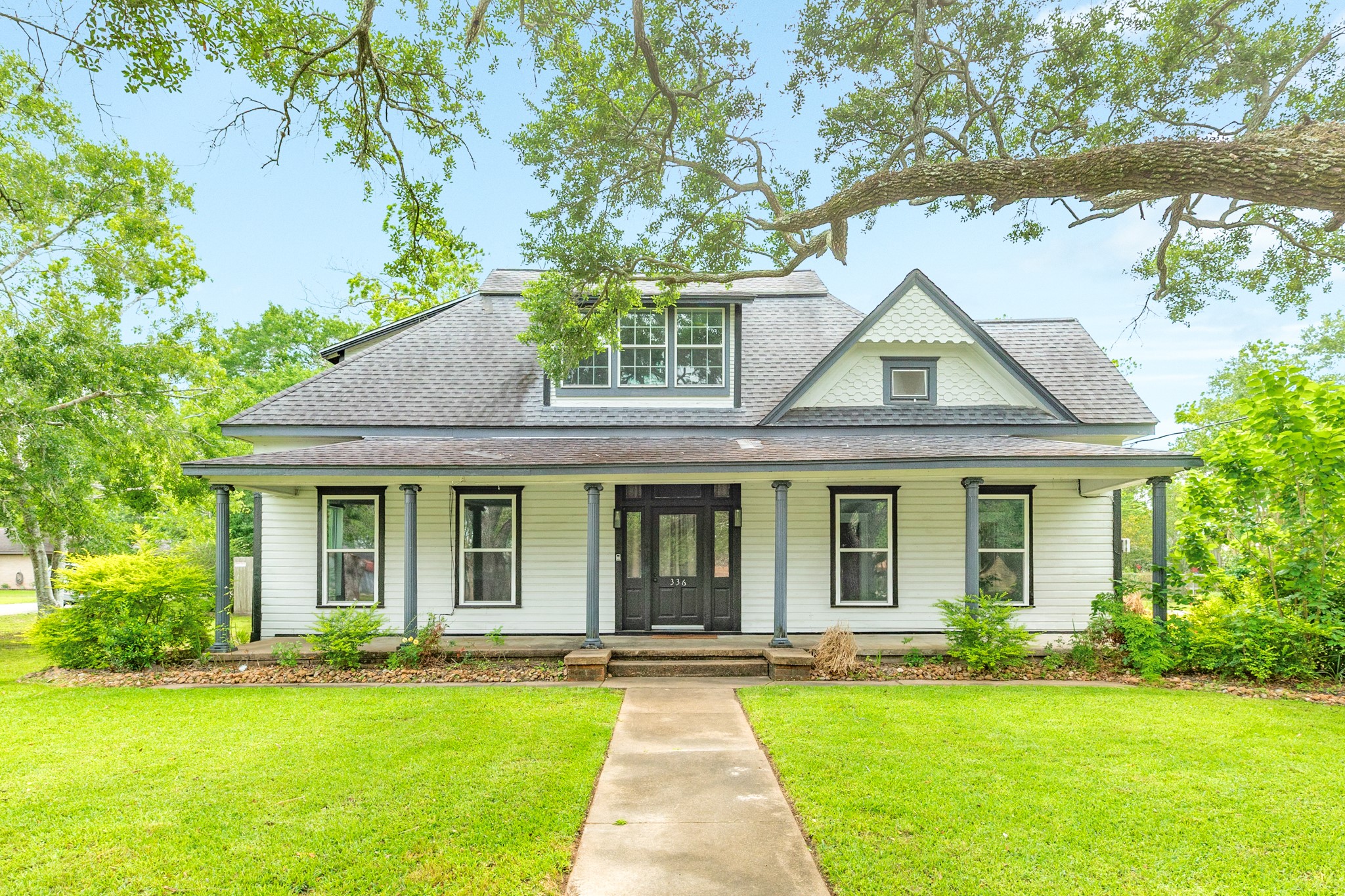 a front view of a house with yard and green space