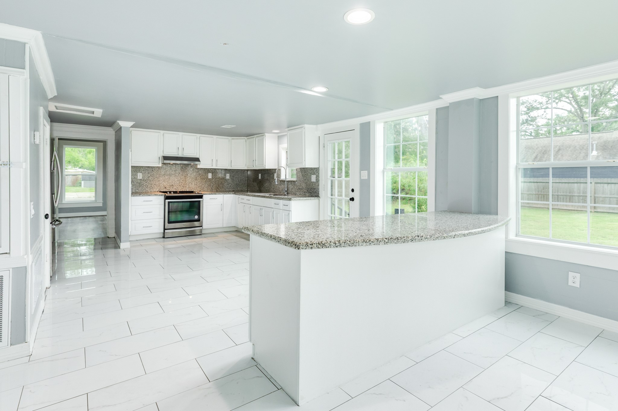 336 North Rockisland Street Angleton, TX 77515 - Photo 12 of 32 a large white kitchen with granite countertop a large window and a counter space