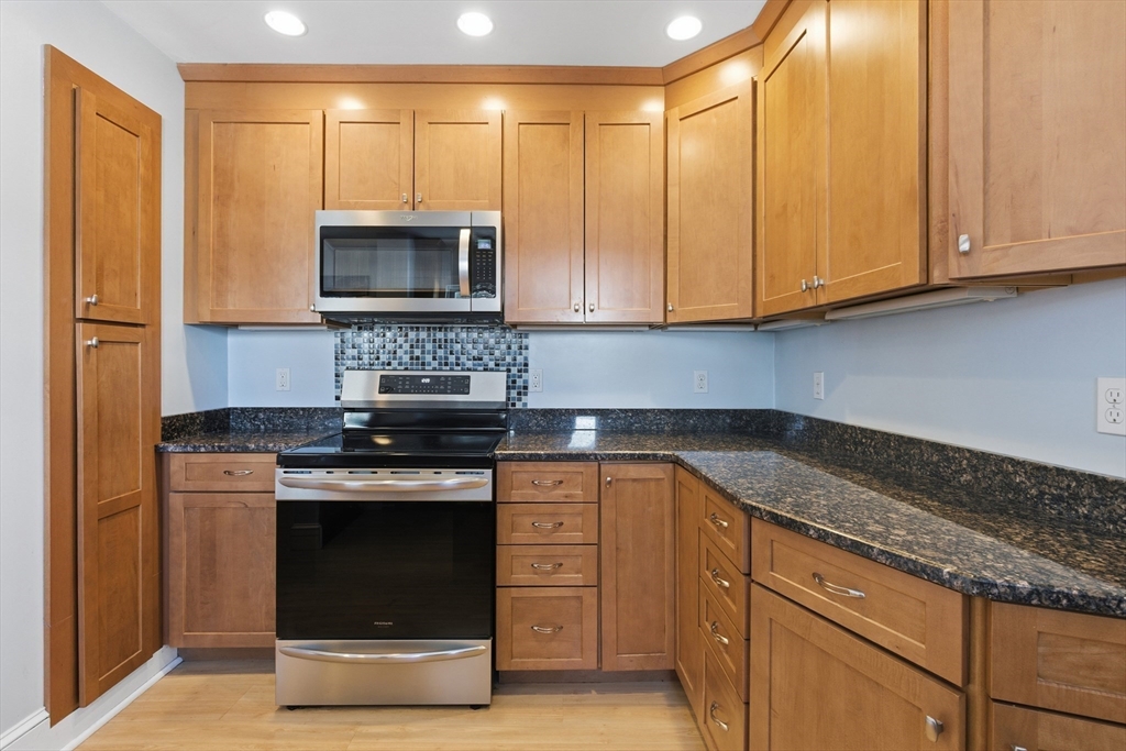 a kitchen with stainless steel appliances granite countertop a stove a sink and a microwave