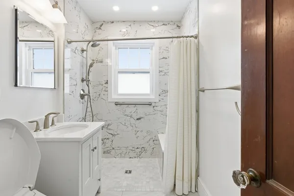 a bathroom with a sink mirror and a shower