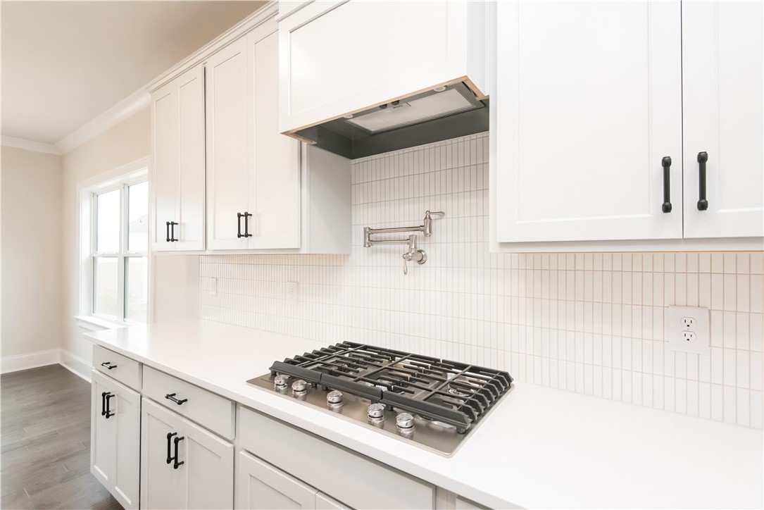 220 Holly Br Road Piedmont, SC 29673 - Photo 17 of 33 This bright kitchen features a gas cooktop, sleek countertops, and classic white cabinetry.