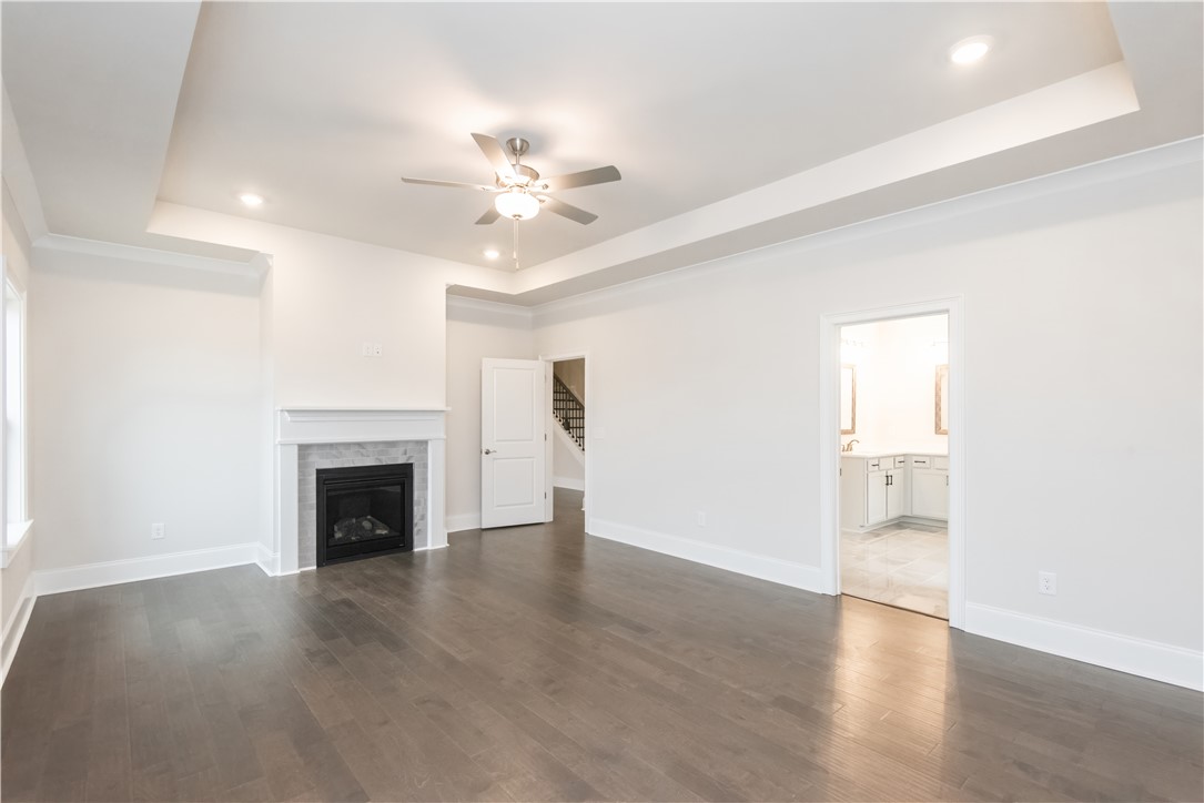 220 Holly Br Road Piedmont, SC 29673 - Photo 25 of 33 An inviting room features a sleek fireplace and rich hardwood flooring, ready for comfortable living.