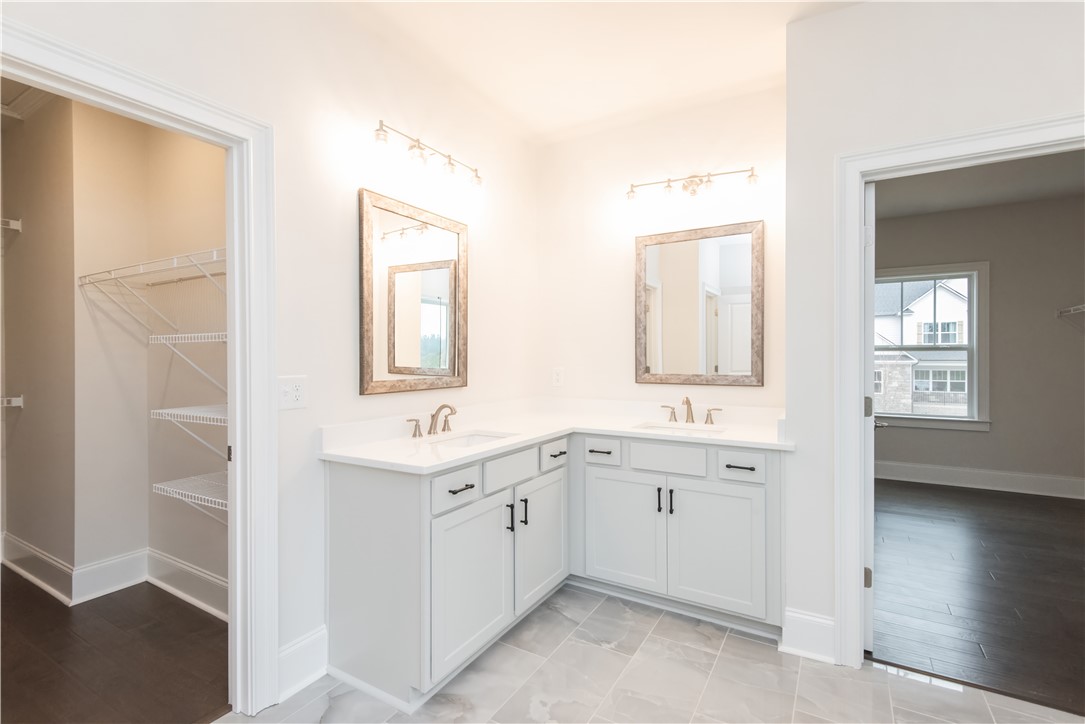 220 Holly Br Road Piedmont, SC 29673 - Photo 28 of 33 This spacious bathroom offers dual vanities, generous counter space, and a walk-in closet for ample storage.