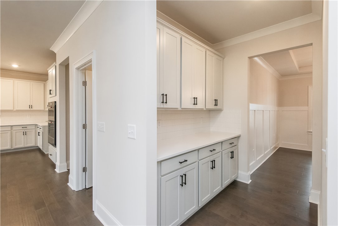 220 Holly Br Road Piedmont, SC 29673 - Photo 7 of 33 This bright kitchen and hallway showcase elegant cabinetry and rich wood flooring.