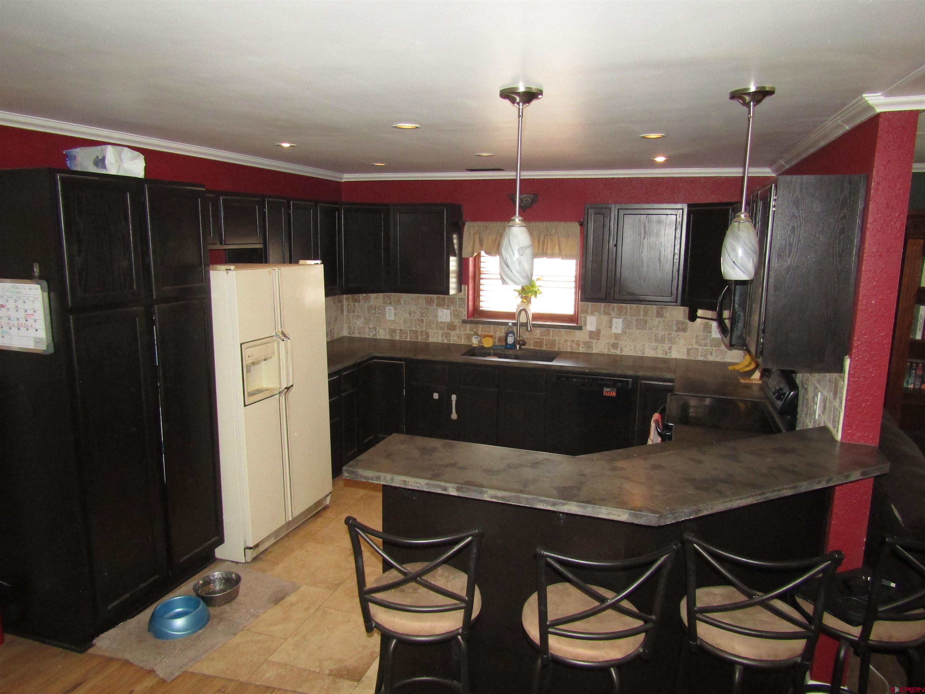 18 Morris Street Monte Vista, CO 81144 - Photo 3 of 14 a kitchen with a table chairs refrigerator and wooden floor