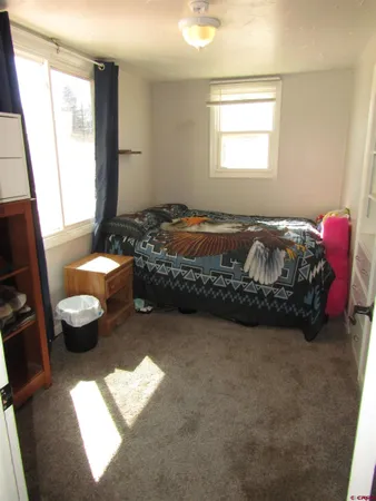 a spacious bedroom with a bed couch and a window