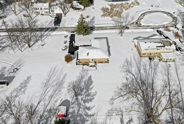 an aerial view of a house with yard and parking