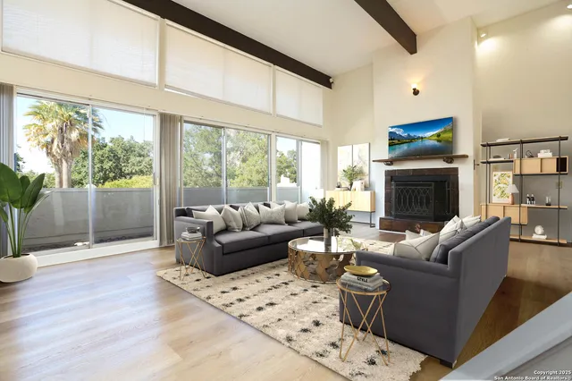 a living room with furniture a large window and a fireplace