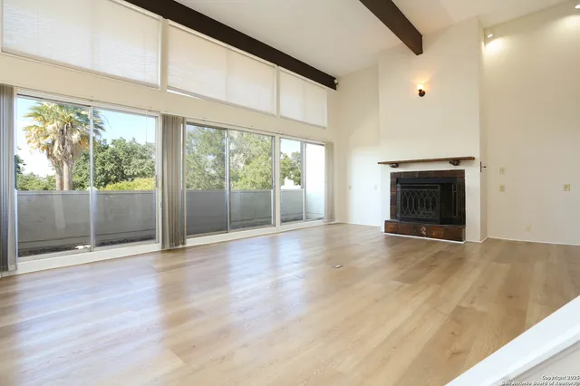 an empty room with wooden floor and outdoor view