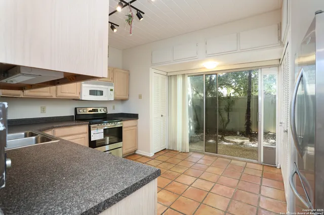 a kitchen with stainless steel appliances granite countertop a refrigerator and a stove top oven