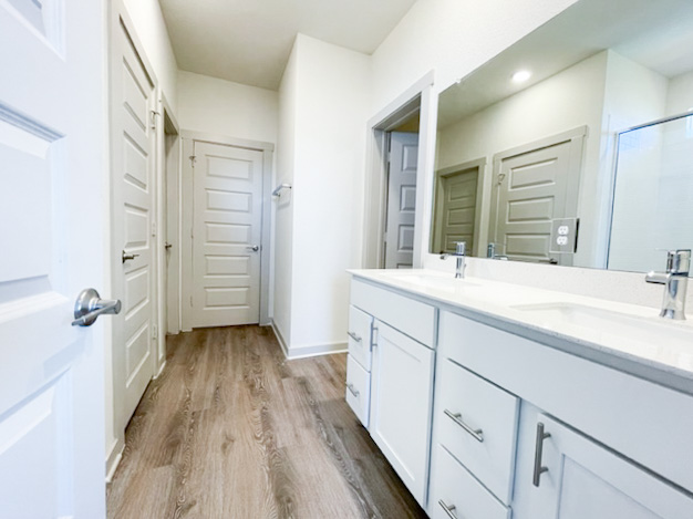 10616 Defender Trail Austin, TX 78754 - Photo 19 of 25 a spacious bathroom with a double vanity sink a mirror and shower