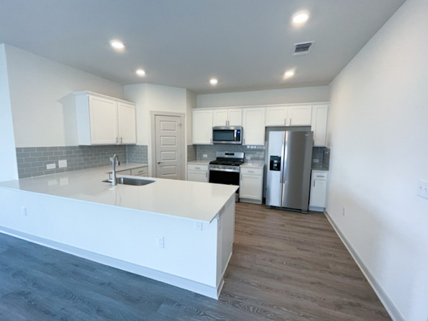 10616 Defender Trail Austin, TX 78754 - Photo 5 of 25 a large kitchen with stainless steel appliances a sink a stove a refrigerator and cabinets