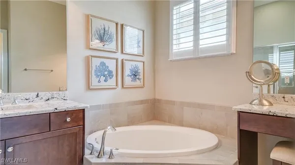 a en suite bathroom with a granite countertop sink a toilet and a mirror