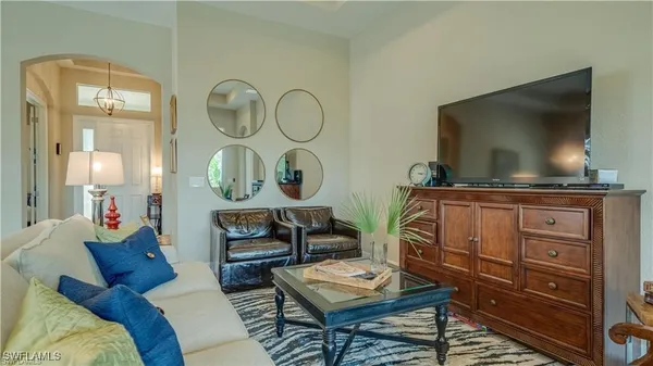 a living room with furniture a flat screen tv and a large window
