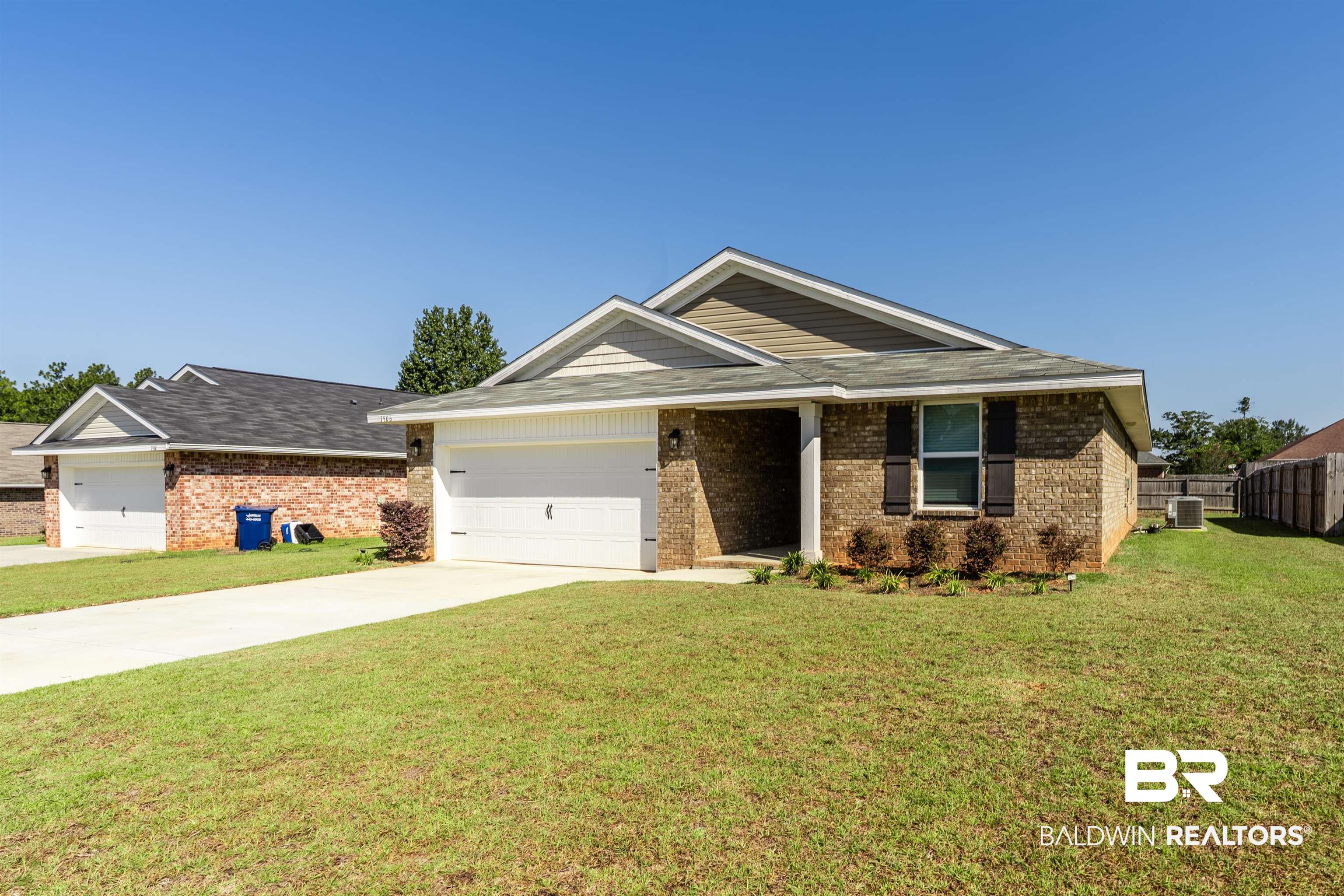 1906 Stonepine Drive South Semmes, AL 36575 - Photo 1 of 30 Ranch-style house featuring a front yard, driveway, brick siding, and a garage