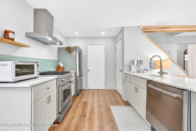 a kitchen with granite countertop a sink and steel appliances