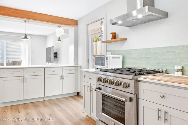 a kitchen with cabinets appliances and wooden floor