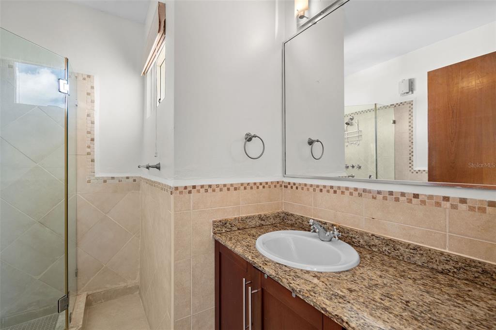 * Academy Drive Drive, Unit 25 Humacao, PR 00791 - Photo 21 of 37 a bathroom with a granite countertop sink and a mirror