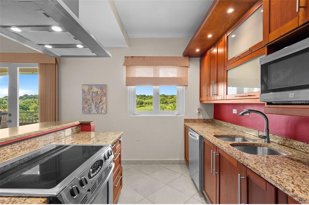 * Academy Drive Drive, Unit 25 Humacao, PR 00791 - Photo 9 of 37 a kitchen with stainless steel appliances granite countertop a sink stove and cabinets