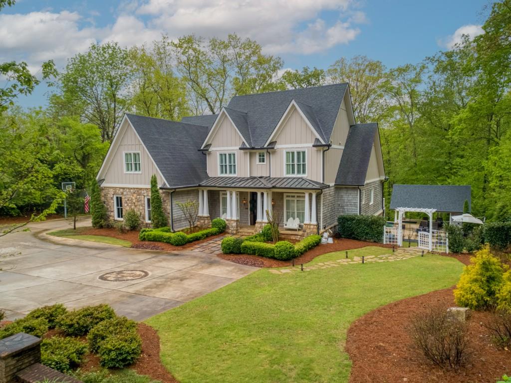 a front view of a house with a yard and potted plants