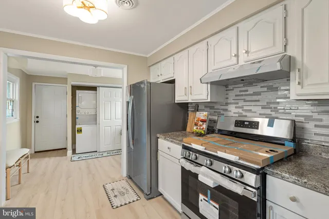 a kitchen with a stove a refrigerator and cabinets