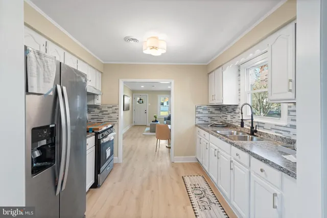 a kitchen with stainless steel appliances granite countertop a refrigerator and a sink