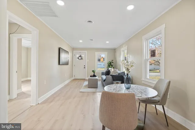 a living room with furniture a large window and wooden floor