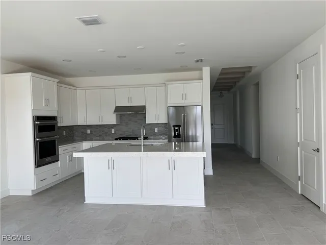 a kitchen with stainless steel appliances a sink stove and refrigerator