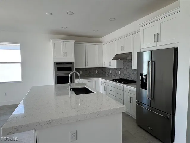 a kitchen with stainless steel appliances a refrigerator sink and stove