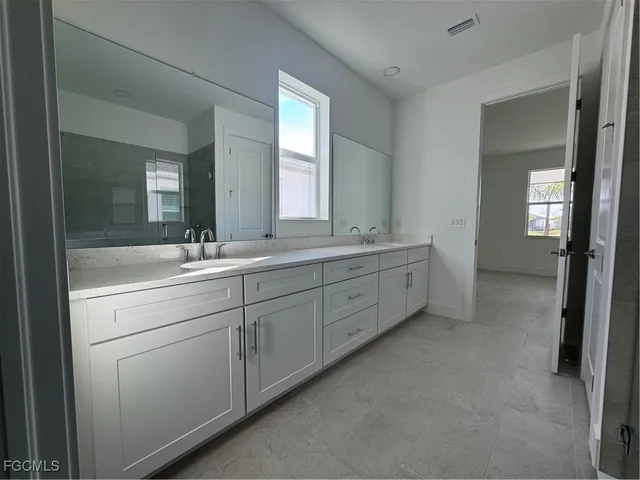 a bathroom with a double vanity sink and a mirror