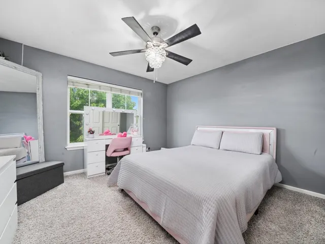 a bedroom with a bed and a large window
