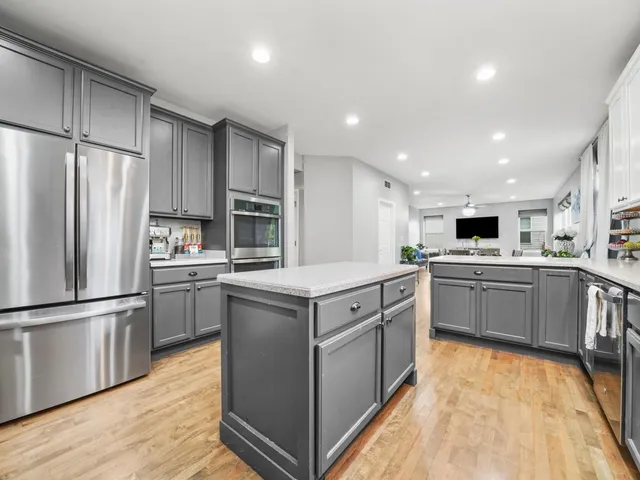 a kitchen with white cabinets stainless steel appliances and center island