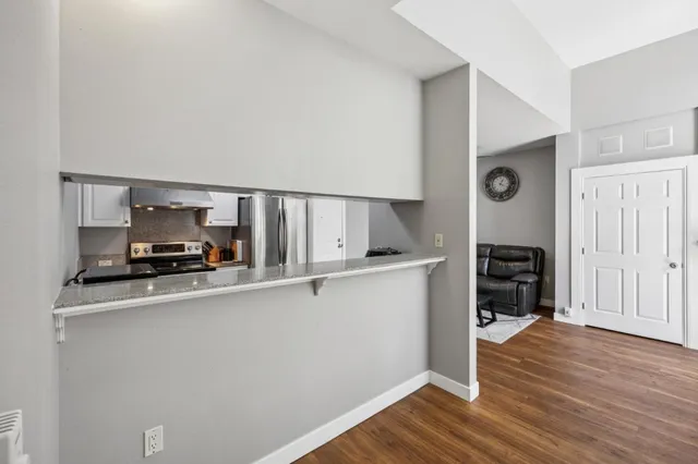 a kitchen with wooden floor and white appliances
