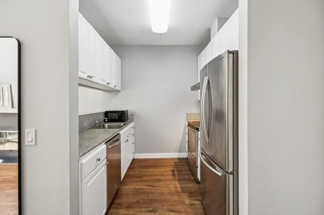 a kitchen with stainless steel appliances granite countertop a refrigerator and a sink