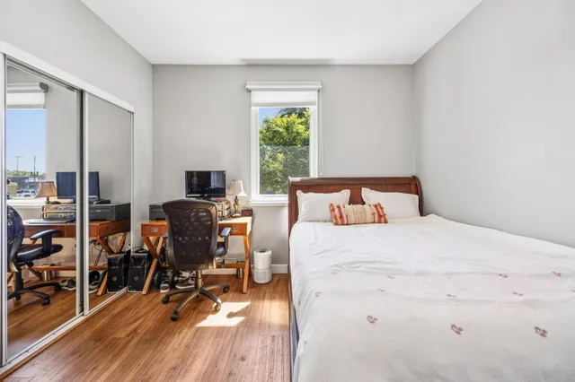a bedroom with a bed a table and a bookshelf