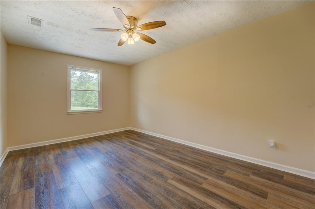 170 Hidden Pines Drive Covington, GA 30016 - Photo 14 of 22 an empty room with wooden floor and windows