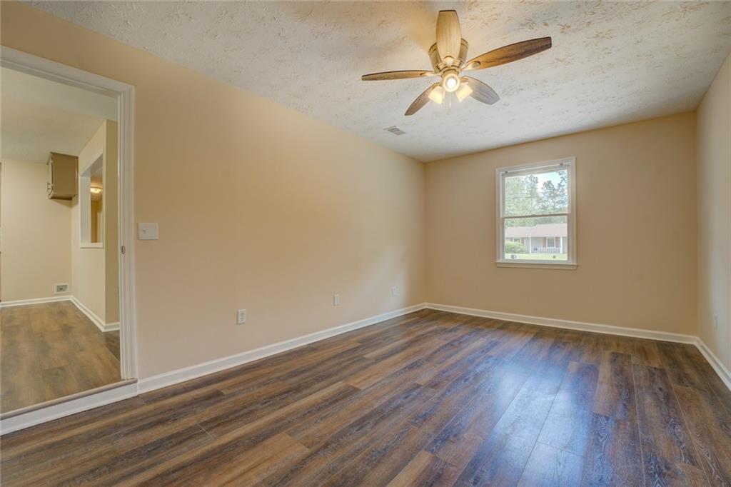 170 Hidden Pines Drive Covington, GA 30016 - Photo 15 of 22 an empty room with wooden floor chandelier fan and windows
